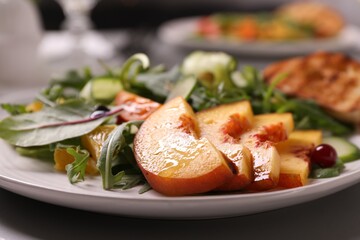 Delicious salad with peach slices on plate, closeup
