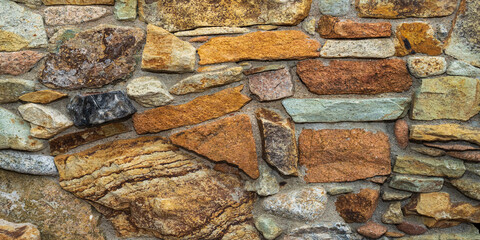 Fragment of a natural stone wall as a background or texture. The structure of the stone wall. Old castle stone wall texture background. Мasonry background