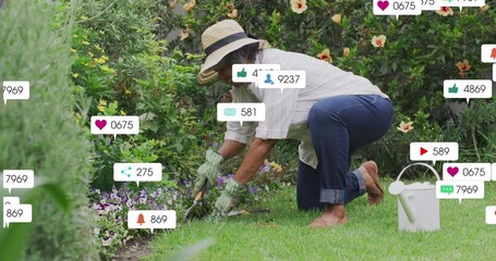Animation of social media icons over happy biracial senior woman gardening in the garden - Powered by Adobe