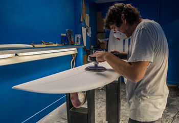 Professional surf shaper in action in his studio - 634808806