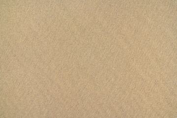 Brauner Sand an einem Strand in Nahaufnahme, glatte feine Textur mit einem Anteil dunkler Körner -...