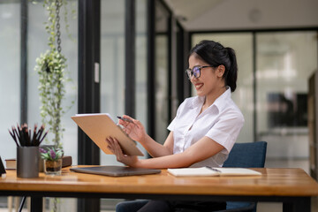 Businesswoman working attentively in front of laptop. Document review, analysis, and planning