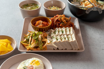 Korean food dish Stir-fried cartilage rice ball, seafood fish cake soup, boiled pork, tofu, kimchi, and stir-fried pork