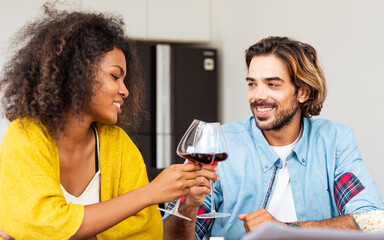African afro woman, caucasian man wearing casual clothes, smiling with happiness, holding wine glass, toasting for party celebration at home with friends. Lifestyle, New Year, Birthday, Event Concept.