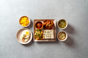 Fototapeta na wymiar Korean food dish Stir-fried cartilage rice ball, seafood fish cake soup, boiled pork, tofu, kimchi, and stir-fried pork