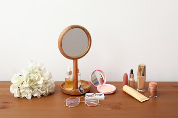 Different decorative cosmetics and mirror on wooden table