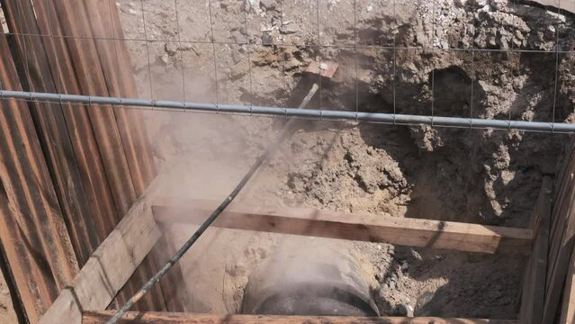 Hot steam comes out of the Underground pipe. Buried for fixing underground hot water supply lines. water boiling in a tube in construction site.