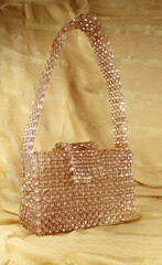 Handmade mink bead bag on cream fabric.