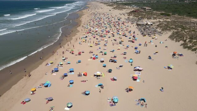 Aerial view of people enjoying summer at the beach in Costa da Caparica, near Lisbon, Portugal.