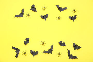 Composition with paper bats and spiders on yellow background. Halloween celebration concept