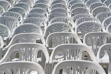 Weiße Plastikstühle vor einer Open-Air-Veranstaltung
