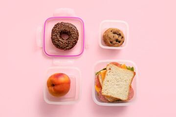 Lunchboxes with different delicious food on pink background