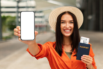 Cheerful Lady Passenger Displaying Smartphone Screen And Boarding Pass Outdoor
