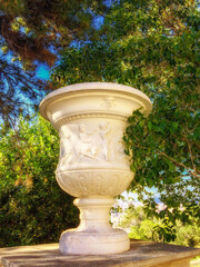 sculpture on the pedestal, branches and leaves against the sky