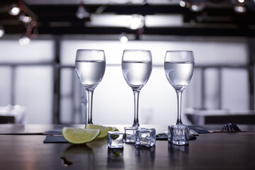 glasses with vodka with lime on the table  on restaurant background