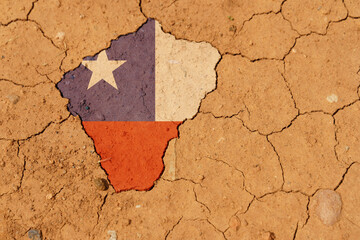 Drought. On dry, cracked ground, the image of the flag of Chile.