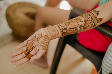 Artist applying henna tattoo on women hands. Mehndi is traditional Indian decorative art.