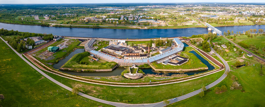 Daugavpils, Latvia - August 13, 2023. Aerial view of Daugavpils prison by the river Daugava. Criminal prison, white building with grilles and iron fences.