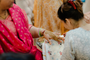Artist applying henna tattoo on women hands. Mehndi is traditional Indian decorative art.