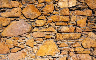 Fragment of a natural stone wall as a background or texture. The structure of the stone wall. Old castle stone wall texture background. Мasonry background