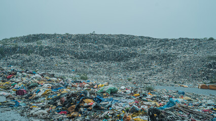 Garbage dumped at landfill against clear sky