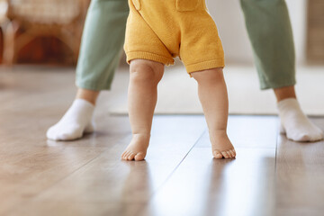 Little baby kid child learn walking in home with mother