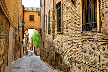Historic street with archway in the Old Town of Toledo, Spain