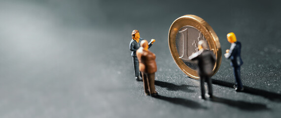 businessmen figurines standing by euro coin. business strategy and planning, economic analysis...