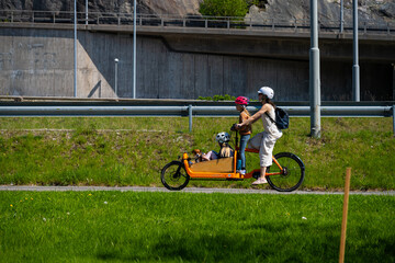 Obraz premium Family travelling on a yellow cargo electric assisted bicycle.
