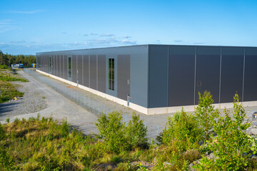 Fototapeta na wymiar Exterior of a new and large grey warehouse.