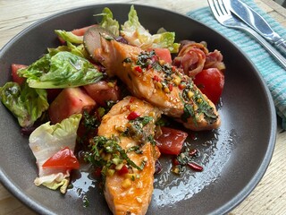 Grilled salmon fish fillet and fresh green leafy vegetable salad with tomatoes, red onion and lettuce. Healthy food. Ketogenic lunch. Top view