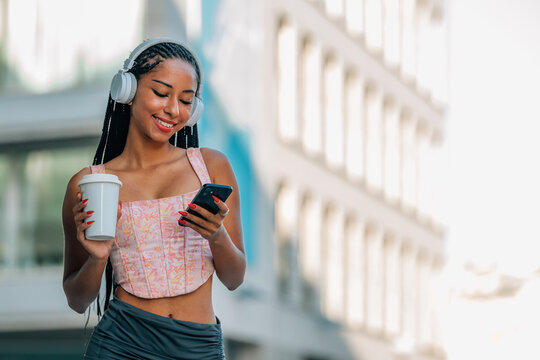 girl on the street with headphones and mobile phone