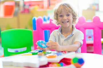 Fototapeta premium Little boy in with toys in school classroom.