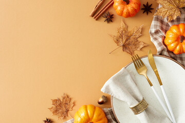 Vibrant autumn table arrangement. Top view shot of plate, cutlery, napkin, tablecloth, pumpkins,...