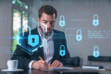 Calm businessman in formal wear signing contract at office workplace with coffee cup, laptop and notebook. Concept of successful deal, agreement, partnership, documents. Lock icons.
