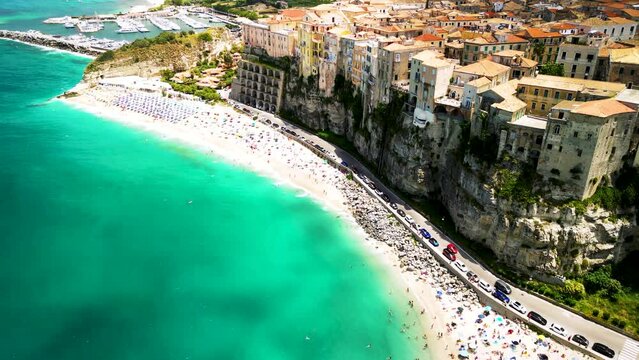 Drone Aerial view of famous town Tropea, Italian coastline with turquoise waters, rugged cliffs, colorful houses