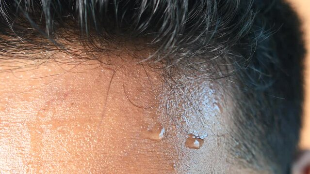 closeup of sweat on forehead against dark background ,