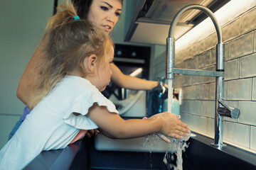 Washing hands in sink; mom's help, hygiene lessons
