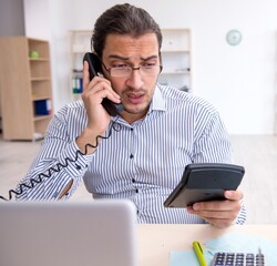 Young male bookkeeper calculating tax payments in the office