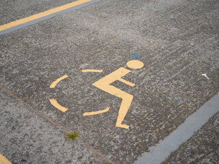 A wheelchair symbol is painted on the street. It marks a parking lot for disabled people.
