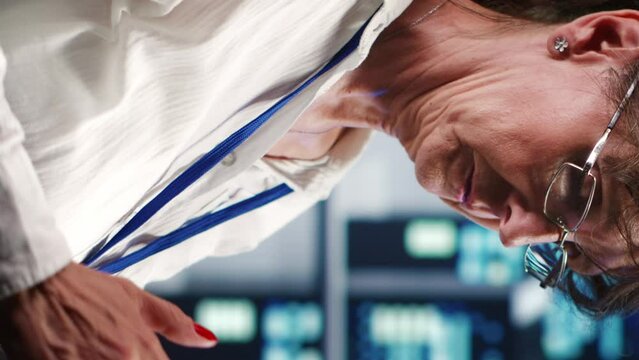 Vertical video Precise system administrator in data center equipped to handle complex computing operations, doing regular upgrades to server parts, increasing processing power to prevent collapse