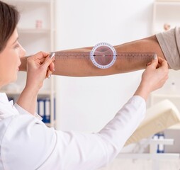 Female doctor checking patient's joint flexibility with goniomet