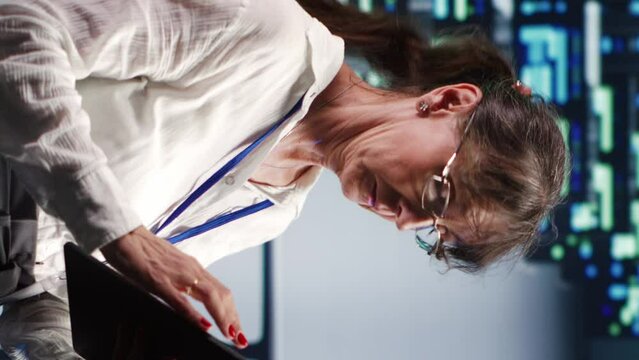 Vertical video Adept supervisor in high tech location equipped to handle modern computing requirements, doing regular upgrades to server cabinets, increasing processing power and storage capacity to