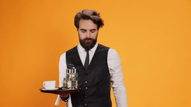 Expert valet posing with meal tray and showcasing stop signal with his palm. Staff of luxury restaurant becoming dissatisfied and rejecting other ideas, declining to comply with them.