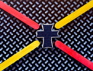 Black & white background has flashy yellow & red pointers. Leather cross made by photographer is outlined in white leather. The cross is the center, the center point.