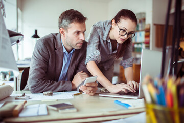 Young man and woman working together on a project in a startup company office