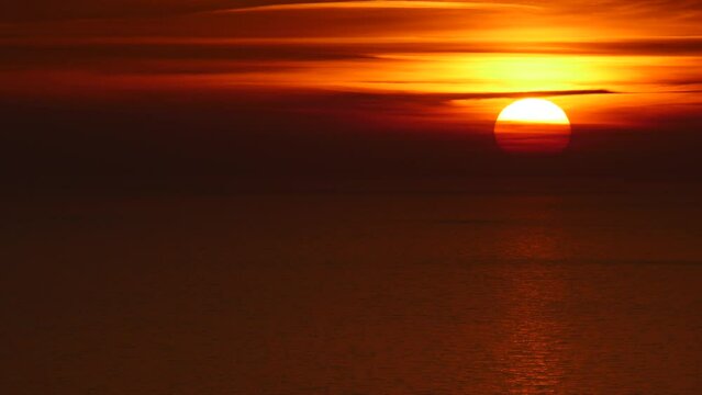 Seascape. Red orange sunset over sea water surface. View from cliffs of Maro Cerro Gordo Natural Park, Malaga province, Costa Del Sol, Andalusia, Spain.