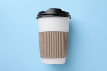 One paper cup on light blue background, top view. Coffee to go