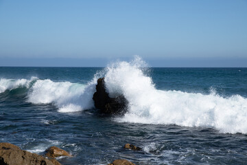 Fototapeta na wymiar waves crashing on rocks at malibu beach