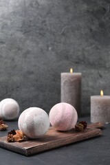 Bath bombs, dry flowers and burning candles on black table